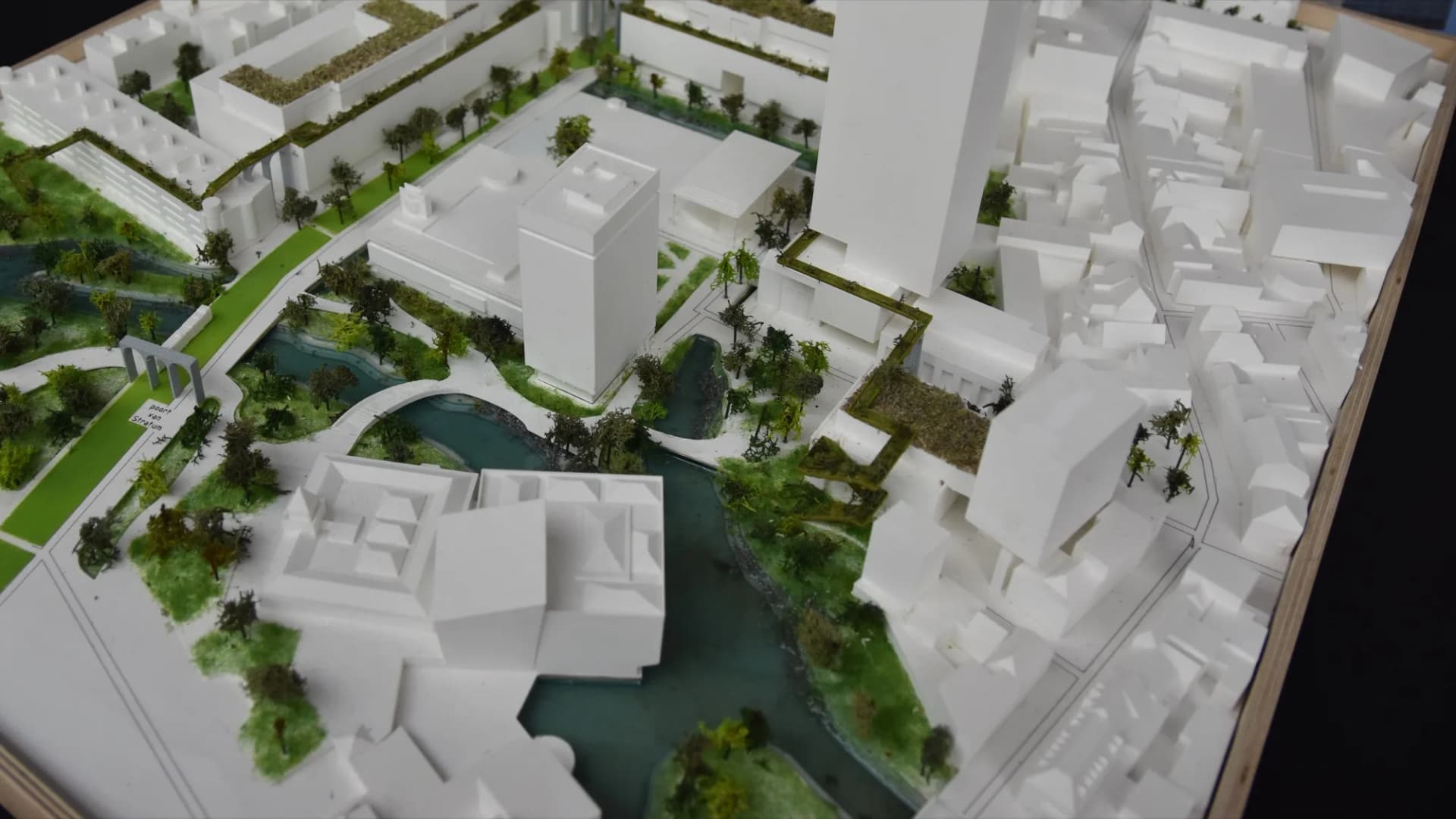 Scale model of a residential development with green areas and water.