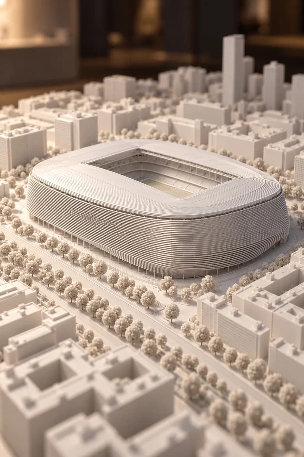 White scale model of a stadium with its urban surroundings and trees.